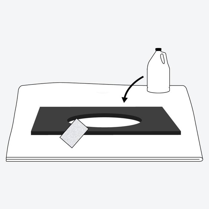 Steps to install undermount sink -  a black vanity top with a sink cutout on a soft surface with sandpaper and denatured alcohol