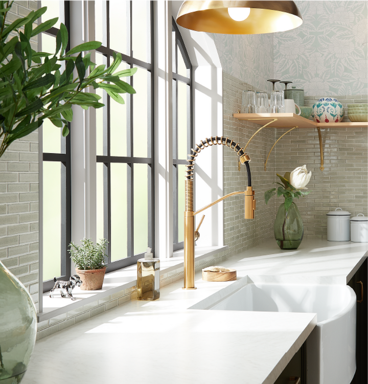 farmhouse kitchen sink with brass faucet and greenery