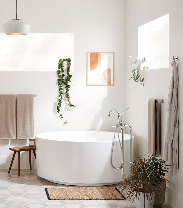 bathroom with round freestanding tub and tub faucet