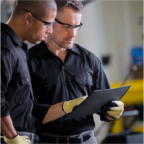 two warehouse employees looking at a clipboard