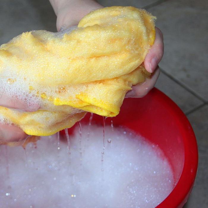 A sponge and bucket with hot water, baking soda and ammonia for cast iron maintenance