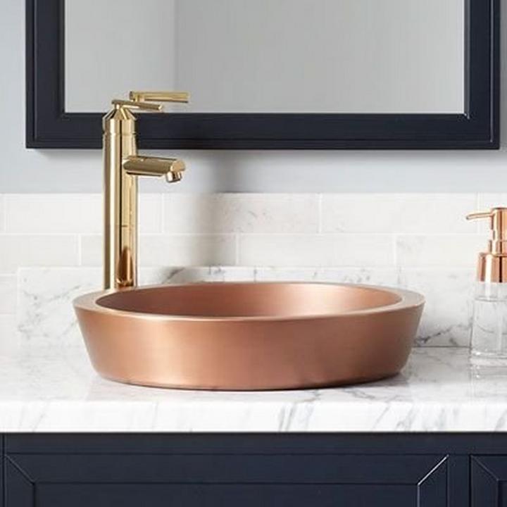 copper bathroom sink with gold faucet