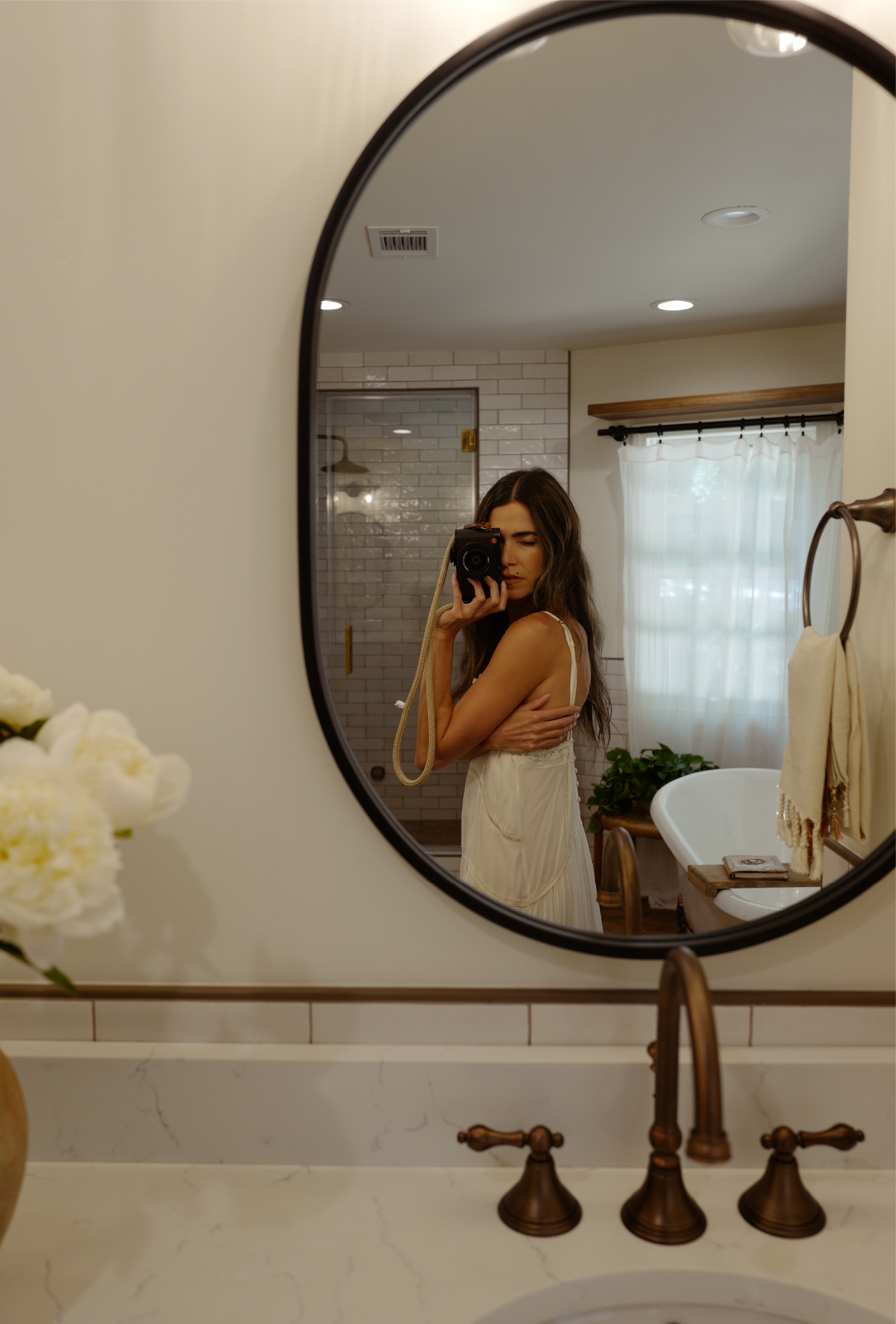Nikki Reed taking a photo in the Colborne Oval Decorative Vanity Mirror - Matte Black