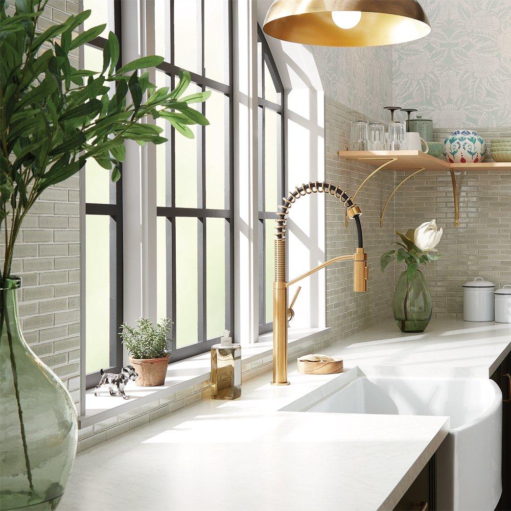 Casey Finn in front of a bathroom sink with brass faucet