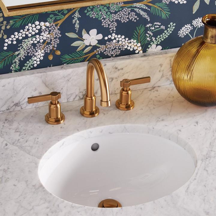 bathroom sink with gold faucet