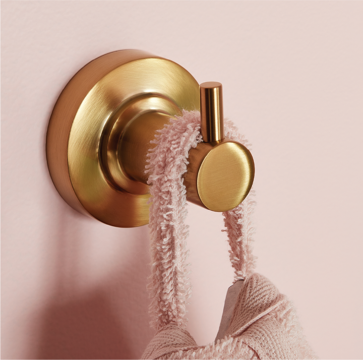 gold robe hook on pink wall
