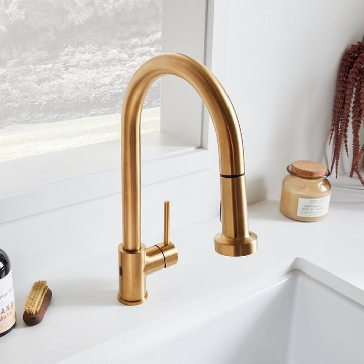 Ridgeway Pull-Down Touchless Kitchen Faucet in Brushed Gold in front of a window