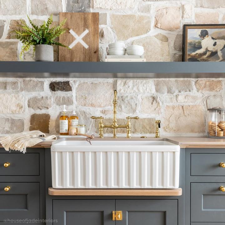 Traditional style kitchen sink with the Bellevue Bridge Kitchen Faucet With Sprayer in Polished Brass