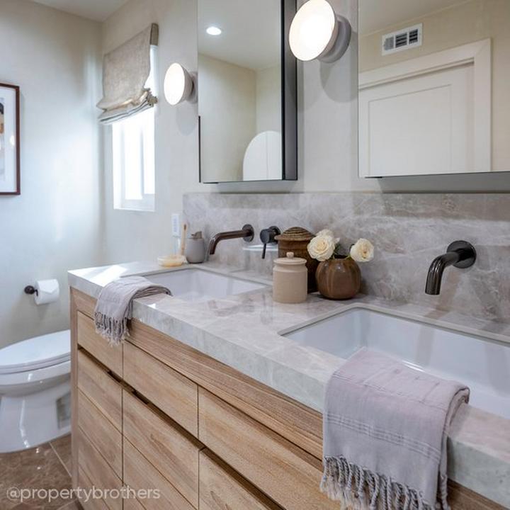 Wabi sabi bathroom designed by the Property Brothers with a teak vanity and matte black wall-mount faucet